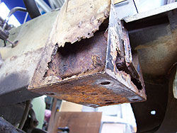Front crossmember mount showing extensive rust damage